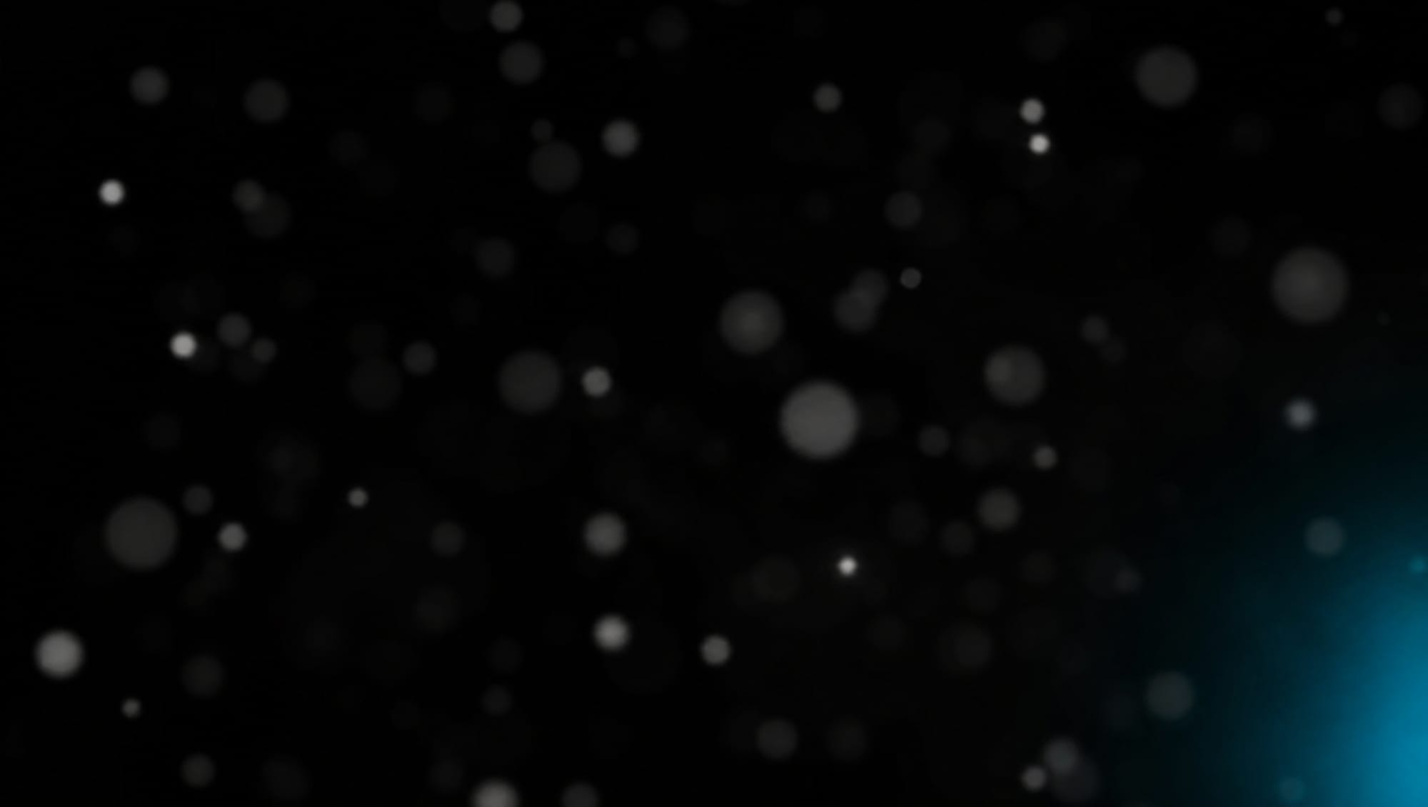 Soft white bokeh in a black void with a faint cyan glow